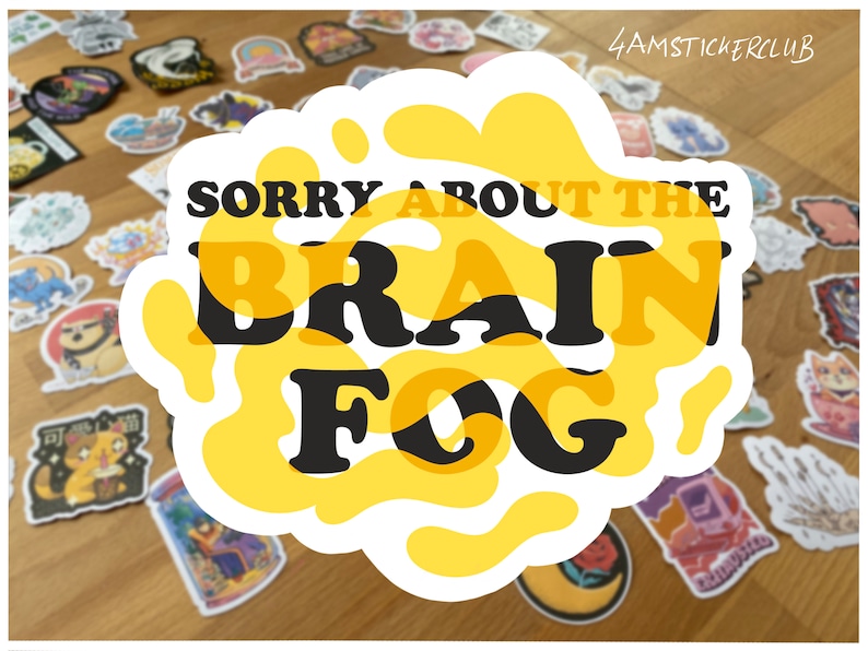 May include: A yellow sticker with a white outline and the text "SORRY ABOUT THE BRAIN FOG" in black letters.