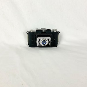 May include: A black Ultra Fox camera with a silver lens and the word "ULTRA" printed on the front.