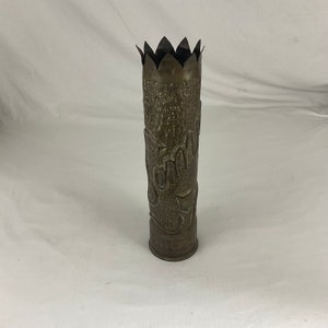 May include: A vintage brass vase made from a repurposed artillery shell. The vase has a scalloped top and is decorated with the word "Somme" and a star.