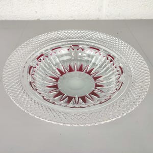 Puede incluir: Un juego de servir de cristal transparente. El plato grande tiene un patrón de diamantes y el cuenco pequeño un diseño de estrella roja. El cuenco está dentro del plato. Ideal para aperitivos.