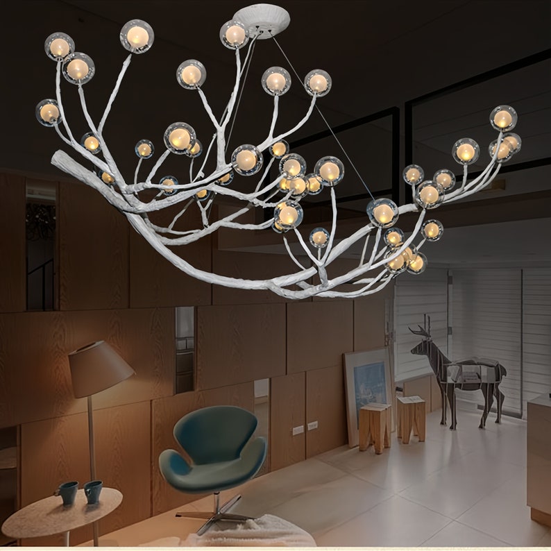 May include: A white, branch-like chandelier with multiple clear glass globes. The chandelier is hanging from the ceiling in a modern living room.