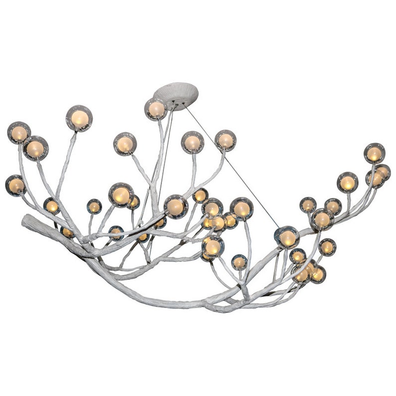 May include: A white, branch-like chandelier with multiple clear glass globes containing small light bulbs. The chandelier is curved and has a modern design.