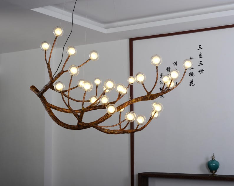 May include: A modern chandelier with a unique branch design and clear glass bulbs. The chandelier is suspended from the ceiling and has a rustic, natural look.