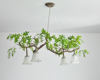 Lampadario scultoreo con rami e foglie verdi artificiali