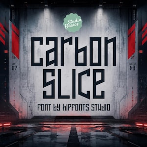 May include: A digital graphic display featuring the text CARBON SLICE in a bold, angular black font. Above the text is a green Studio Basics logo. Below, the text reads FONT BY HIPFONTS STUDIO. The background shows a dark, industrial corridor.