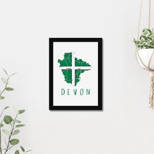 May include: A framed print of a map of Devon, England, with the county's flag superimposed on it. The flag is white with a green cross. The text "DEVON" is printed below the map.