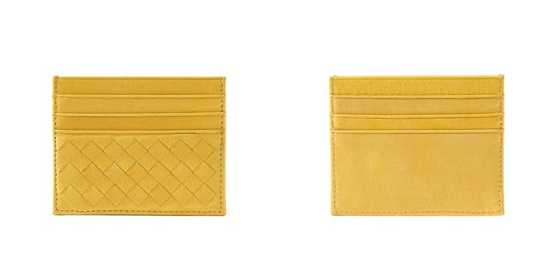 Puede incluir: Se muestran dos tarjeteros amarillos. Uno presenta un dise&ntilde;o tejido en la parte delantera, el otro una superficie lisa. Ambos tienen m&uacute;ltiples ranuras para tarjetas y est&aacute;n hechos de un material similar al cuero.