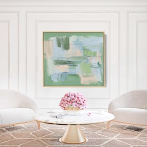 May include: A living room interior with two cream armchairs, a marble coffee table, and an abstract painting with green, blue, and beige tones. A pink floral display is on the table. The room has a neutral colour palette.