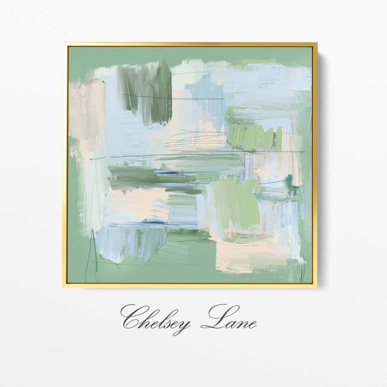 May include: Abstract art print in a gold frame. The artwork features brushstrokes in shades of green, blue, and cream. The text "Chelsey Lane" is at the bottom of the frame. The painting has a modern, minimalist style.