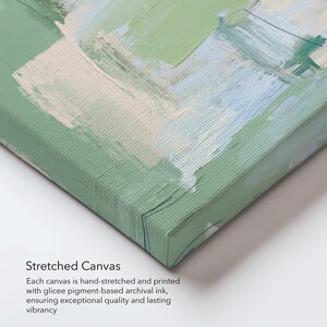 May include: A corner view of a stretched canvas art print. The artwork features abstract brushstrokes in shades of green, white, and blue. The canvas is hand-stretched and printed with archival ink, ensuring quality and vibrancy. The text "Stretched Canvas" is visible.