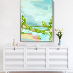 May include: Abstract landscape painting with a blue, green, and pink color scheme. The painting depicts a river flowing through a lush green landscape with a cloudy sky above.
