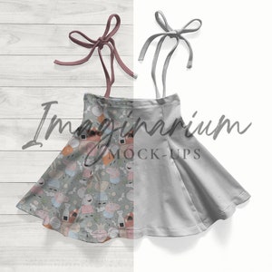 May include: A split-design skirt with a playful pattern on one side and solid gray on the other. The patterned side features cartoon characters in pastel colors. The skirt has tie straps and the text "Imaginarium MOCK-UPS".