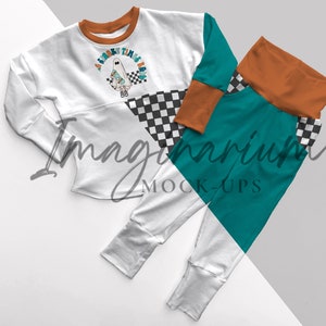 May include: White long-sleeve shirt with a checkered pattern and a ghost graphic with the text "A spooky time is here".  Matching teal and orange pants with a checkered pattern.
