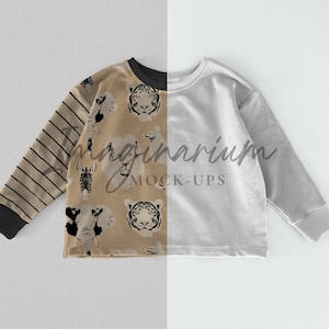 May include: A long-sleeved, light brown sweatshirt with a black and white animal print on one side and a solid light gray color on the other side. The animal print features a zebra, lion, tiger, and elephant. The sweatshirt has a crew neck and long sleeves.