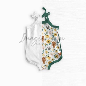 May include: White baby romper with a farm animal and sunflower print. The romper has a green trim and tie straps. The design features illustrations of cows, chickens, pigs, and sunflowers.