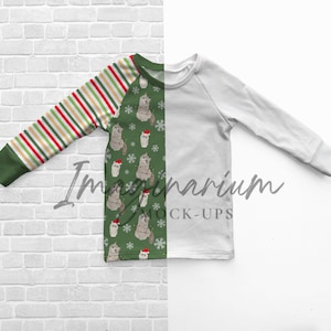 Pode incluir: Uma camisa de manga comprida com um padrão de Natal verde e branco com um animal de desenho animado usando um chapéu de Papai Noel. A camisa tem uma manga listrada vermelha, branca e verde.