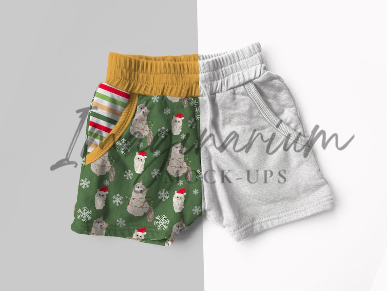 May include: A pair of green and white patterned shorts with a yellow waistband and a red and white striped pocket. The shorts are next to a pair of gray shorts with a white waistband.