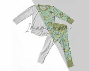 May include: A two-piece pajama set featuring a light green top and pants. The top and pants have a pattern of green dinosaurs, candy canes, and stars. The sleeves and cuffs are light gray, and the collar and cuffs are green.