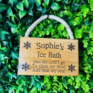 Puede incluir: Un letrero de madera con un colgador de cuerda, que presenta el texto "Sophie's Ice Bath" y un poema sobre tomar un baño frío para limpiar la mente y sanar el alma.