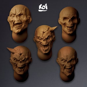 May include: Five ceramic sculptures of grotesque faces with exaggerated features, including horns and fangs. The sculptures are painted in a brown color and have a textured surface.