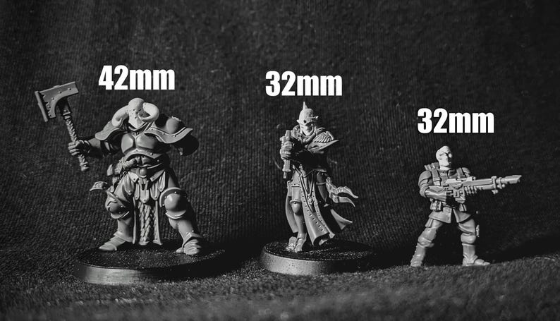K&ouml;nnte beinhalten: Drei Miniaturfiguren, in Grau bemalt, stehen auf runden Sockeln. Die Figuren sind unterschiedlich gro&szlig; und mit 42 mm, 32 mm und 32 mm beschriftet.