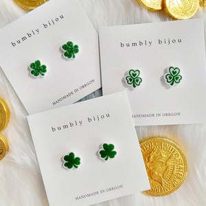 K&ouml;nnte beinhalten: Drei wei&szlig;e Karten mit dem Text "bumbly bijou" und "HANDMADE IN OREGON" darauf. Jede Karte hat zwei gr&uuml;ne Kleeblatt-Ohrringe.