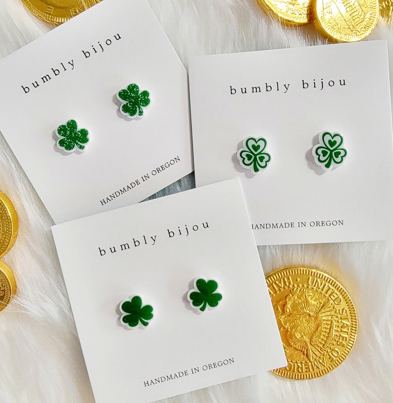 K&ouml;nnte beinhalten: Drei wei&szlig;e Karten mit dem Text "bumbly bijou" und "HANDMADE IN OREGON" darauf. Jede Karte hat zwei gr&uuml;ne Kleeblatt-Ohrringe.