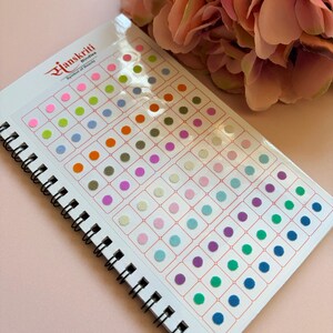 May include: A spiral-bound booklet containing a collection of small, circular adhesive bindis in a wide variety of colours including pink, green, orange, blue, and purple. The cover features the text Sanskriti Bindies Symbol of Beauty.