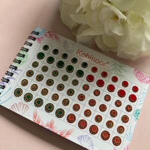 May include: A sheet of green and red decorative stickers with gold accents. The stickers are arranged in rows and columns on a white background. The sheet is labelled "Kohinoor".