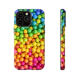 Puede incluir: Una funda de teléfono colorida con un patrón de gominolas de colores arcoíris. La funda está diseñada para adaptarse a un iPhone.