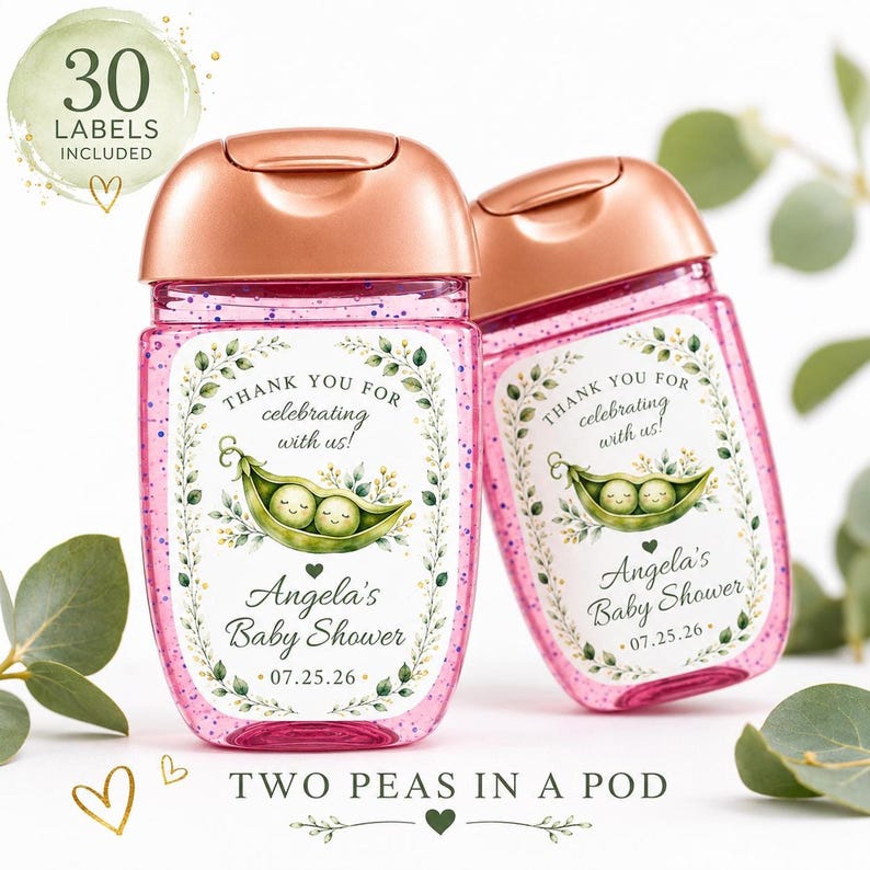 Two hand sanitizer bottles containing pink glitter and topped with rose gold caps feature custom pea pod baby shower labels against a white and green backdrop.