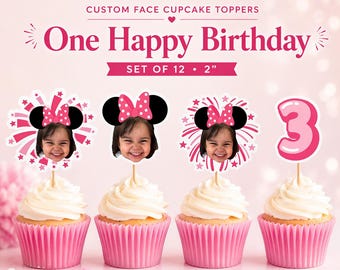 Könnte beinhalten: Rosa Cupcakes mit weißem Zuckerguss und individuellen Tortenauflegern. Die Aufleger zeigen das Gesicht eines Kindes mit Minnie-Maus-Ohren und einer rosa Schleife. Der Text lautet "One Happy Birthday" und "Set of 12 • 5 cm".