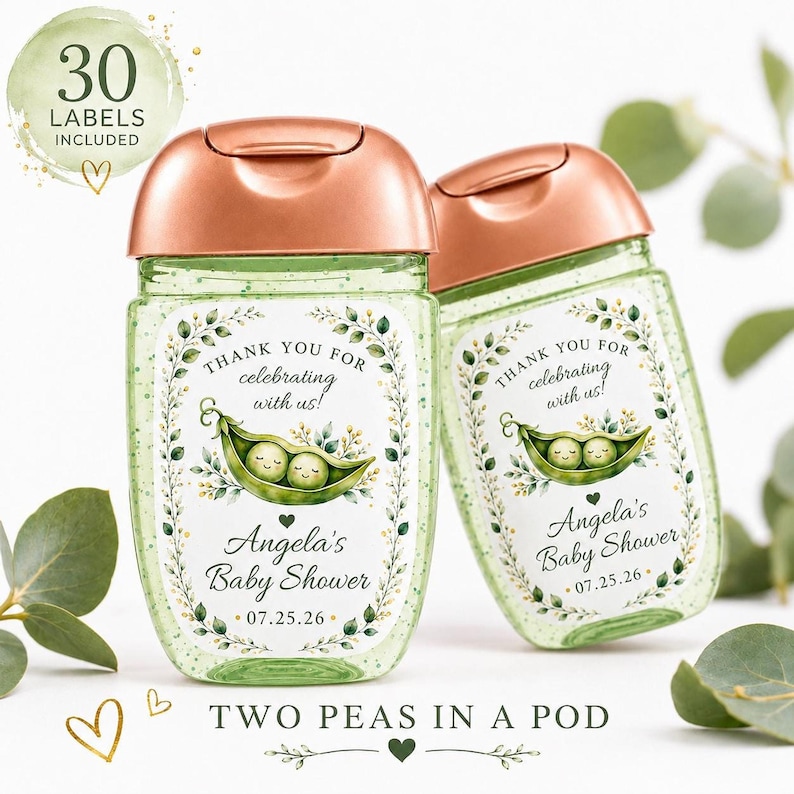 Two clear hand sanitizer bottles with rose gold caps and green glitter gel, decorated with custom pea in a pod labels, are displayed against a white background with eucalyptus leaves.
