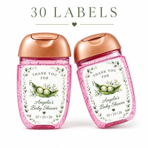 Two hand sanitizer bottles with pink glitter gel and rose gold pumps display custom baby shower favor labels with a pea in a pod theme.