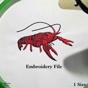 May include: Embroidered design of a red crawfish with black outlines. The crawfish is in a curled position with its claws extended. The design is on a white fabric background. The text "Embroidery File" is below the crawfish.