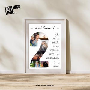 Ein gerahmter Druck mit weißem Rand. Der Druck zeigt eine große "2", die aus mehreren Fotos eines Paares besteht. Der Text enthält "name 1 & name 2" und Zeitangaben auf Deutsch, wie "2 Jahre" und "24 Monate".