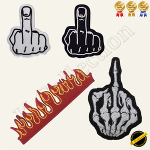 May include: Four embroidered iron-on patches. One is a white hand giving the middle finger, another is a black hand giving the middle finger, another is a red and yellow flame, and the last is a white skeleton hand giving the middle finger.
