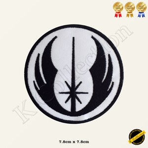 May include: A white and black embroidered patch featuring the Jedi Order symbol. The symbol is a white lightsaber with a black star at the centre, surrounded by two black wings. The patch is 7.8 cm in diameter.