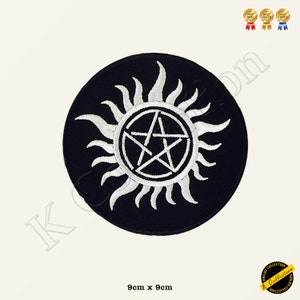Könnte beinhalten: Runder, schwarzer Aufnäher mit einem weißen Pentagramm-Design, umgeben von einem Sonnenstrahlenmuster. Misst 9 cm x 9 cm. Das Design ist mit weißem Faden gestickt. Geeignet für Kleidung oder Accessoires.