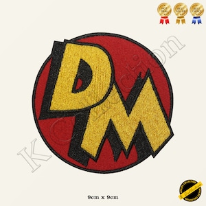 May include: An embroidered patch featuring the letters "D" and "M" in a circle, with red and yellow colours. The patch measures 9 cm by 9 cm.