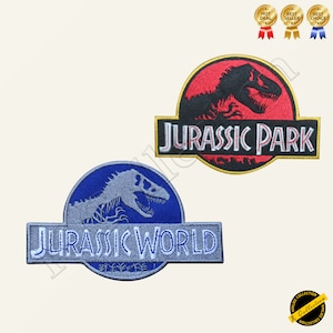May include: Two embroidered iron-on patches featuring the Jurassic Park and Jurassic World logos. The Jurassic Park patch is red and black with a black dinosaur silhouette. The Jurassic World patch is blue and grey with a grey dinosaur skeleton silhouette.