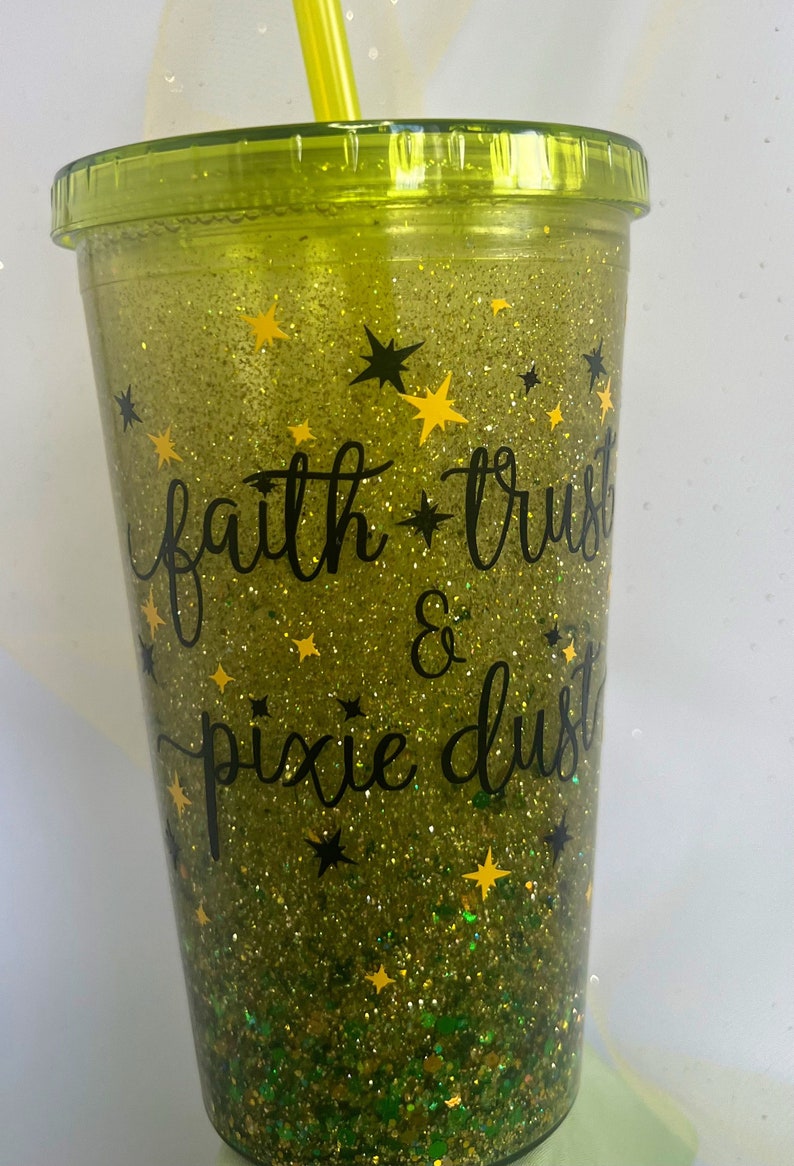 Peut inclure: Un gobelet vert &agrave; paillettes avec un motif &agrave; paillettes noires et dor&eacute;es. Le gobelet porte l'inscription "faith * trust & pixie dust".