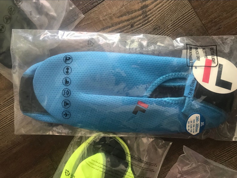May include: A blue and black athletic shirt with a white logo and the text "Skin Suit" and "Ultra Light, Next Fit, Quick Dry, Breathable". The shirt has a size tag that says "XL 280-300cm, USA L/XL, EUR L/XL, UK L/XL".