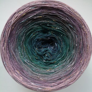 May include: A skein of yarn with a gradient of colors from purple to teal with gold and silver glitter threads.