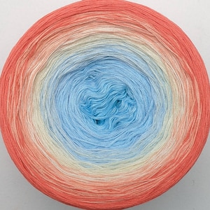 May include: A ball of yarn with a gradient of colors from coral to light blue. The yarn is wound into a tight coil, creating a circular shape.