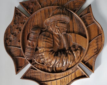 May include: A wooden wall hanging depicting a carved firefighter in a helmet and gear, set within a Maltese cross design. The wood has a rich, brown finish, and the carving details include the American flag and stars.