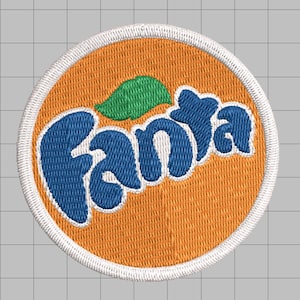 Könnte beinhalten: Ein kreisförmiger, bestickter Aufnäher mit orangefarbenem Hintergrund und weißem Rand. Das Wort Fanta ist in blauen Buchstaben mittig aufgestickt, unterhalb einer kleinen grünen Blattgrafik. Das Design liegt auf einem grauen Rasterhintergrund.