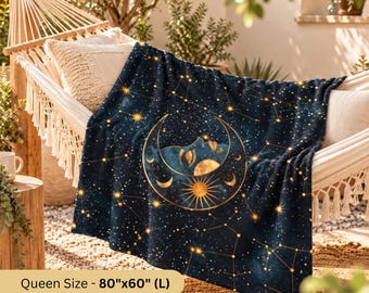 May include: A dark blue blanket featuring a gold celestial print of a crescent moon with a face, a sun, and scattered stars. The blanket is labeled as Queen Size measuring 80 inches by 60 inches, draped over a white woven hammock.
