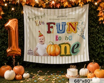 May include: A large rectangular fabric backdrop featuring a beige and white striped pattern with the text Welcome to Guillermo's First Birthday and It's FUN to be one. The banner displays a photo of a baby, a pumpkin, and a cake illustration.