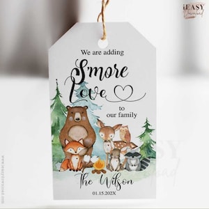 May include: A white thank you tag featuring a watercolour illustration of woodland animals gathered around a campfire. The text reads "We are adding S'more Love to our family The Wilson 01.15.202X".